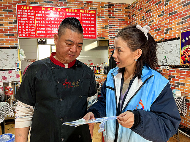 社区工作人员正在向商户进行政策宣传_副本.jpg