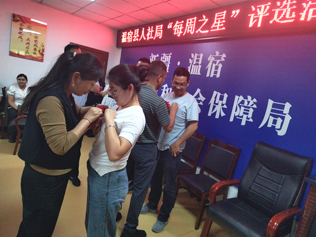 近日，该县人社局在全局系统内组织开展了2023年度“最美人社人---每周之星”评选活动，温宿县人社局党组成员、公共就业服务局局长魏勇给为“每周之星”佩戴表彰花环。（江凯摄）_副本.jpg