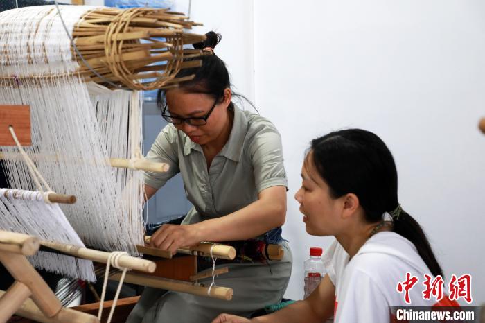 图为蒙丽再传授学员编织技艺。　环江毛南族自治县融媒体中心供图