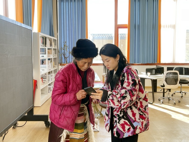 图为王舒（右）帮助居民采集医保照片信息_副本.jpg